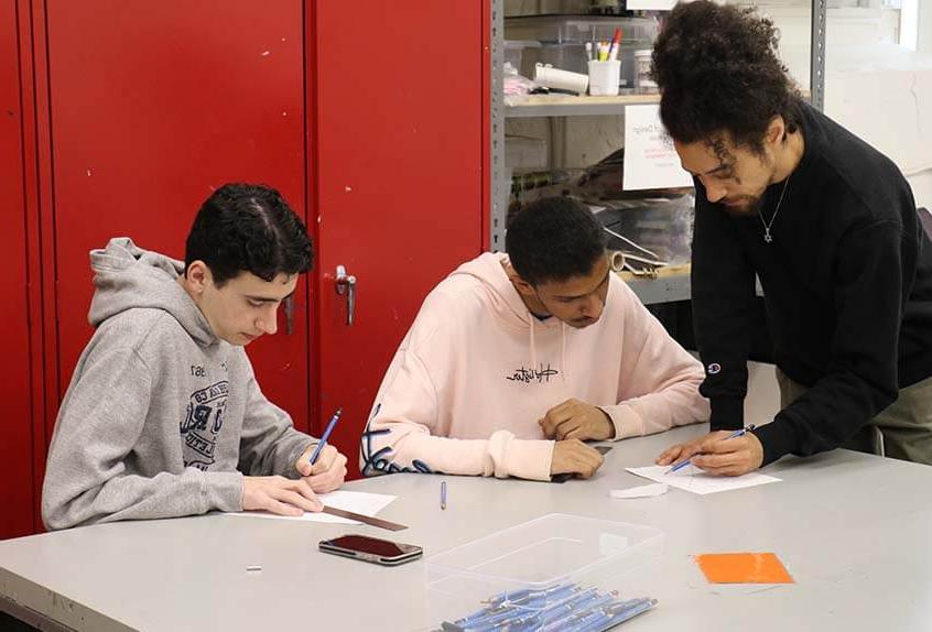 Teacher Dan Herwitt works with students in his Graphic Novels class